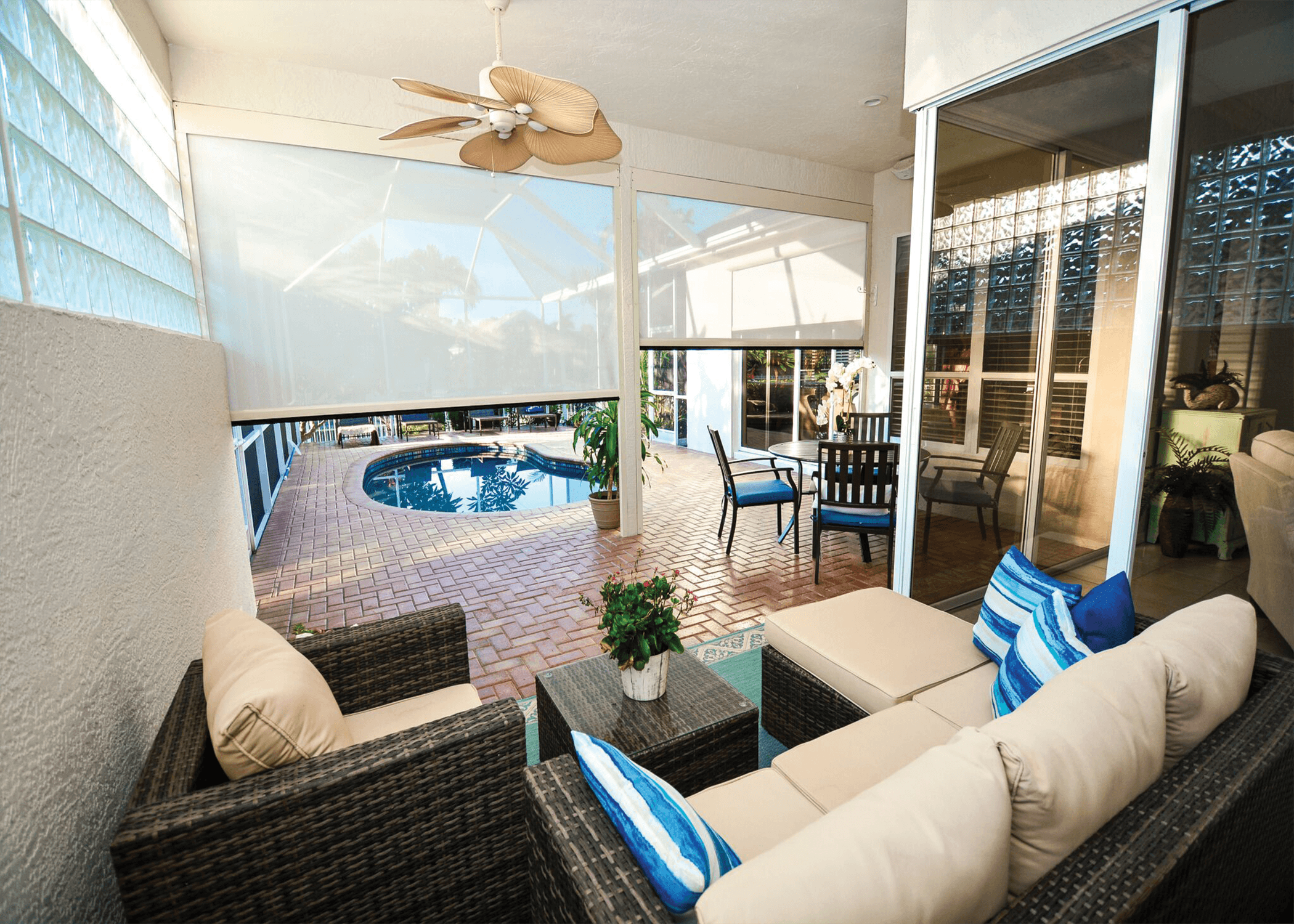 Comfortable lanai seating area with sun-control screens overlooking a screened pool enclosure