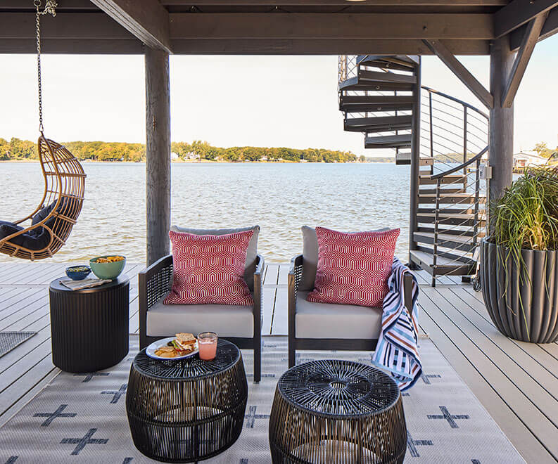 Trex Spiral Stairs Summit with a charcoal-black aluminum frame on a lakeside dock at dusk